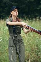 mulher soldado verde macacão braços dentro a mãos do estilo de vida armas verde foto