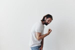 feliz homem ouvindo para música e sorridente dentro uma branco camiseta em uma branco fundo feliz foto