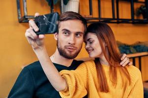 mulher com Móvel telefone e feliz homem amigos Diversão família comunicação interior foto