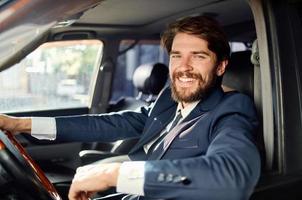 barbudo homem dirigindo uma carro viagem luxo estilo de vida comunicação de telefone foto