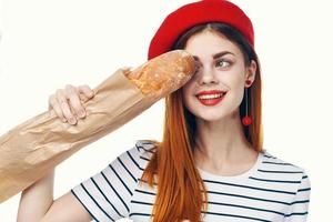 mulher dentro uma vermelho chapéu com uma francês pão dentro dela mãos uma lanche gourmet estilo de vida foto