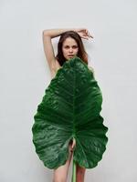 mulher com nu corpo cobre ela mesma com verde folha foto