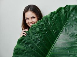 sorridente mulher verde Palma folha exótico cortada Visão foto