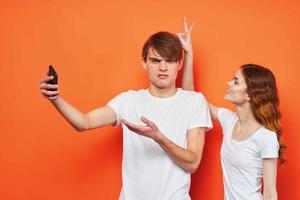 alegre jovem casal com telefones dentro mãos moda tecnologia foto