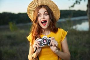 surpreso mulher com Câmera amarelo camiseta chapéu verão natureza estilo de vida foto