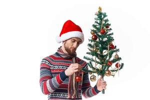 bonito homem dentro uma santa chapéu Natal decorações feriado Novo ano estúdio posando foto