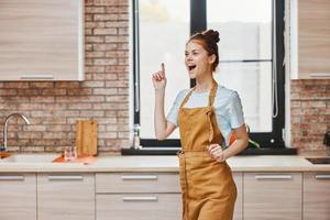 uma dona de casa gestos com dele mãos cozinha apartamento cozinha utensílios interior família conceito foto