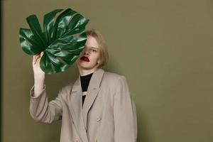 retrato do uma mulher verde Palma folha casaco brilhante Maquiagem estilo de vida posando foto