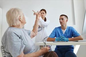 fêmea paciente comunica com médico e enfermeira assistente dentro hospital foto