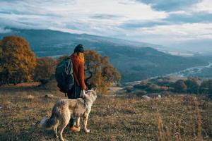 mulher caminhante natureza montanhas viagem Próximo para a cachorro liberdade amizade foto
