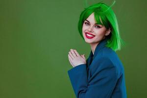bonita jovem fêmea atraente Veja verde peruca azul Jaqueta posando verde fundo inalterado foto