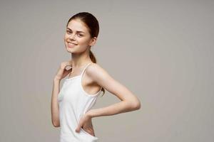 alegre mulher dentro branco camiseta aquecer ombros saúde foto