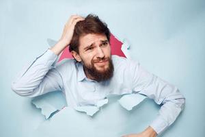 emocional homem dentro azul camisa rompe através parede emoções cortada Visão escritório foto
