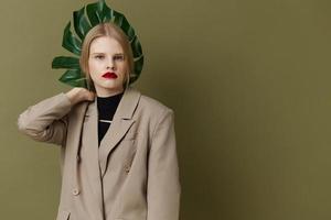 retrato do uma mulher verde Palma folha casaco brilhante Maquiagem estúdio modelo inalterado foto