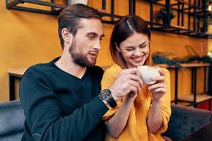 uma mulher dentro amor com uma copo do café e uma feliz homem às uma mesa dentro uma cafeteria interior amigos comunicação