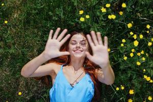 mulher sorrir com dentes mentiras em a verde Relva com amarelo flores, felicidade sem alergias foto