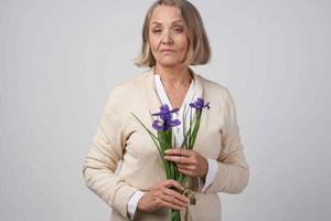 idosos mulher com uma ramalhete do flores presente carinhoso aniversário foto