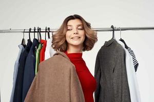 alegre mulher tentando em roupas fazer compras viciado em compras isolado fundo foto