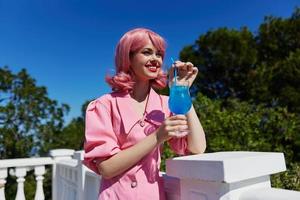 glamouroso mulher com Rosa cabelo verão coquetel refrescante beber verão dia foto