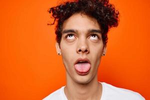 cara com encaracolado cabelo dentro uma branco camiseta emoções fechar acima foto