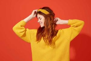 mulher dentro uma amarelo suéter com uma curativo em dela cabeça hipster acessórios estúdio foto