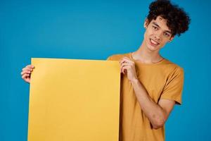 cara com encaracolado cabelo do amarelo ásteres dentro dele mãos estúdio azul fundo foto