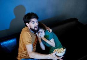 emocional homem e mulher assistindo televisão dentro de casa foto