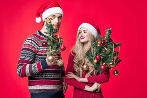 uma homem e uma mulher estão em pé Próximo para Natal decorações Diversão feriado foto