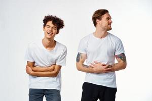 dois homem dentro branco Camisetas estão em pé Próximo para amizade emoções foto