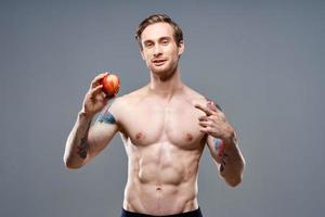 homem com maçã e esporte saudável Comida bombeado acima bolo fisiculturista foto