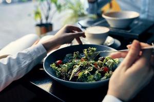 fresco salada dentro uma prato delicioso Comida dieta garfo dentro mão fêmea mãos cafeteria foto