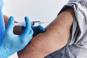 médico e paciente braço injeção vacina Passaporte imunidade proteção foto