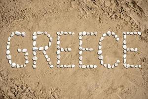 Grécia - palavra fez com pedras em areia foto