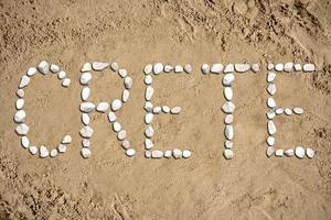 Creta - palavra fez com pedras em areia foto