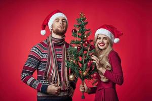 alegre jovem casal Novo ano árvore decoração vermelho fundo foto