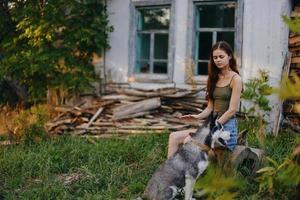 mulher e dela rouco cachorro alegremente jogando ao ar livre dentro a parque entre a árvores sorrir com dentes dentro a outono andar com dela animal foto