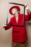 bonita mulher quadro, Armação dentro mão dentro vermelho chapéu e Jaqueta isolado fundo foto