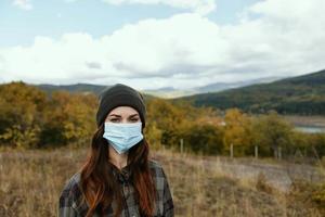 uma mulher dentro uma médico mascarar é em repouso dentro a floresta dentro natureza dentro outono foto