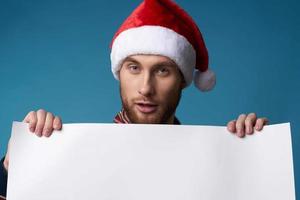 bonito homem dentro uma santa chapéu segurando uma bandeira feriado azul fundo foto