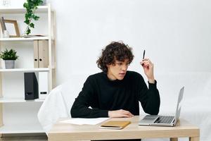 homem em uma branco sofá dentro frente do uma computador portátil Aprendendo comunicação foto