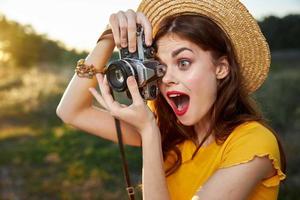 mulher fotógrafo parece para dentro a Câmera lente com aberto boca surpreso Veja natureza foto