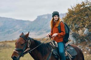 mulher caminhante passeios uma cavalo em natureza dentro a montanhas foto