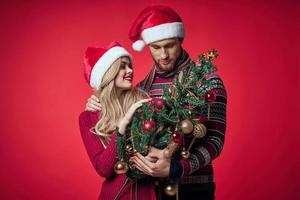 homem e mulher Natal árvore brinquedos Diversão feriado vermelho fundo foto