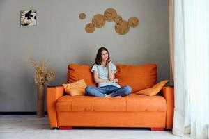 mulher em a sofá descansar Diversão conforto apartamentos foto