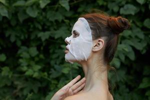 lindo mulher branco mascarar pele Cuidado verde folhas dentro a fundo lado Visão foto