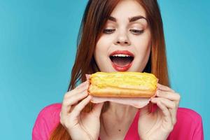 alegre mulher com eclairs dentro mãos fechar-se lanche glamour foto