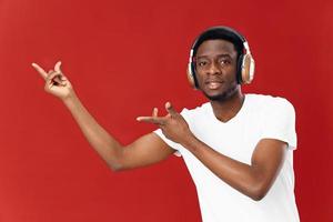 homem do africano aparência dentro fones de ouvido dentro uma branco camiseta música entretenimento foto