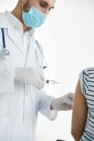 masculino médico dentro uma branco casaco injeções dentro a braço com uma vacina coronavírus foto