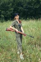 militares mulher arma dentro mão Caçando estilo de vida verde folhas foto