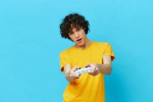 homem tocam com controle de video game dentro amarelo Camisetas azul fundo foto